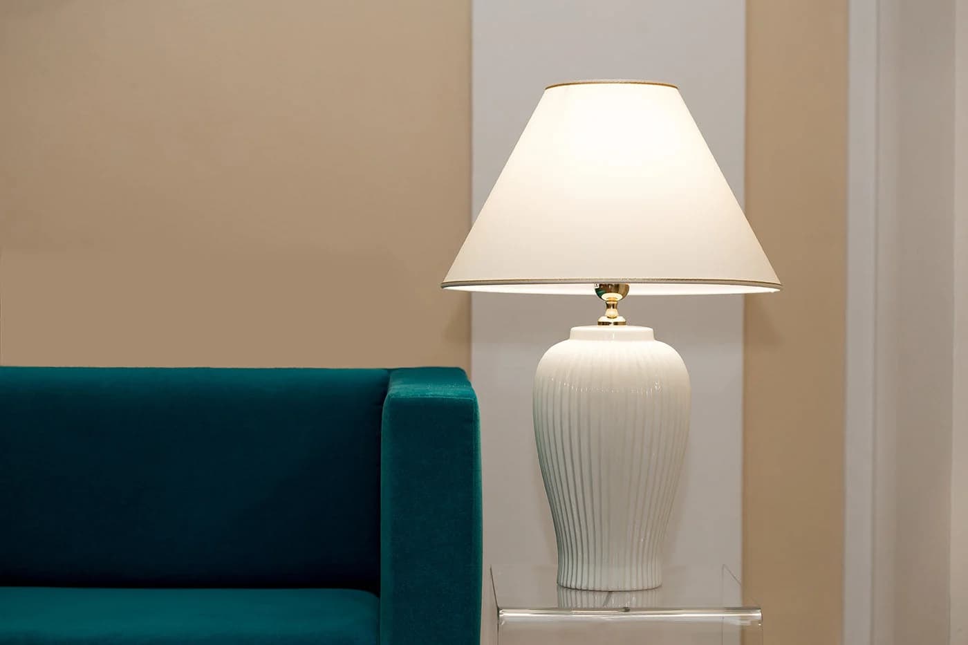 Lunatre Keramik-Tischlampe neben einem Samtsofa im Wohnzimmer
